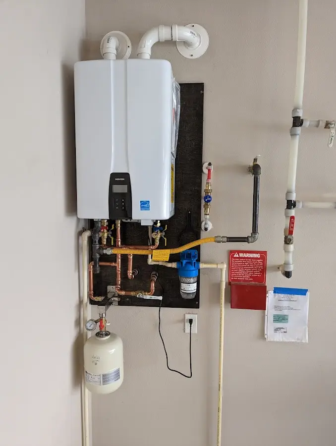 Professional plumber installing copper piping in a Berne home